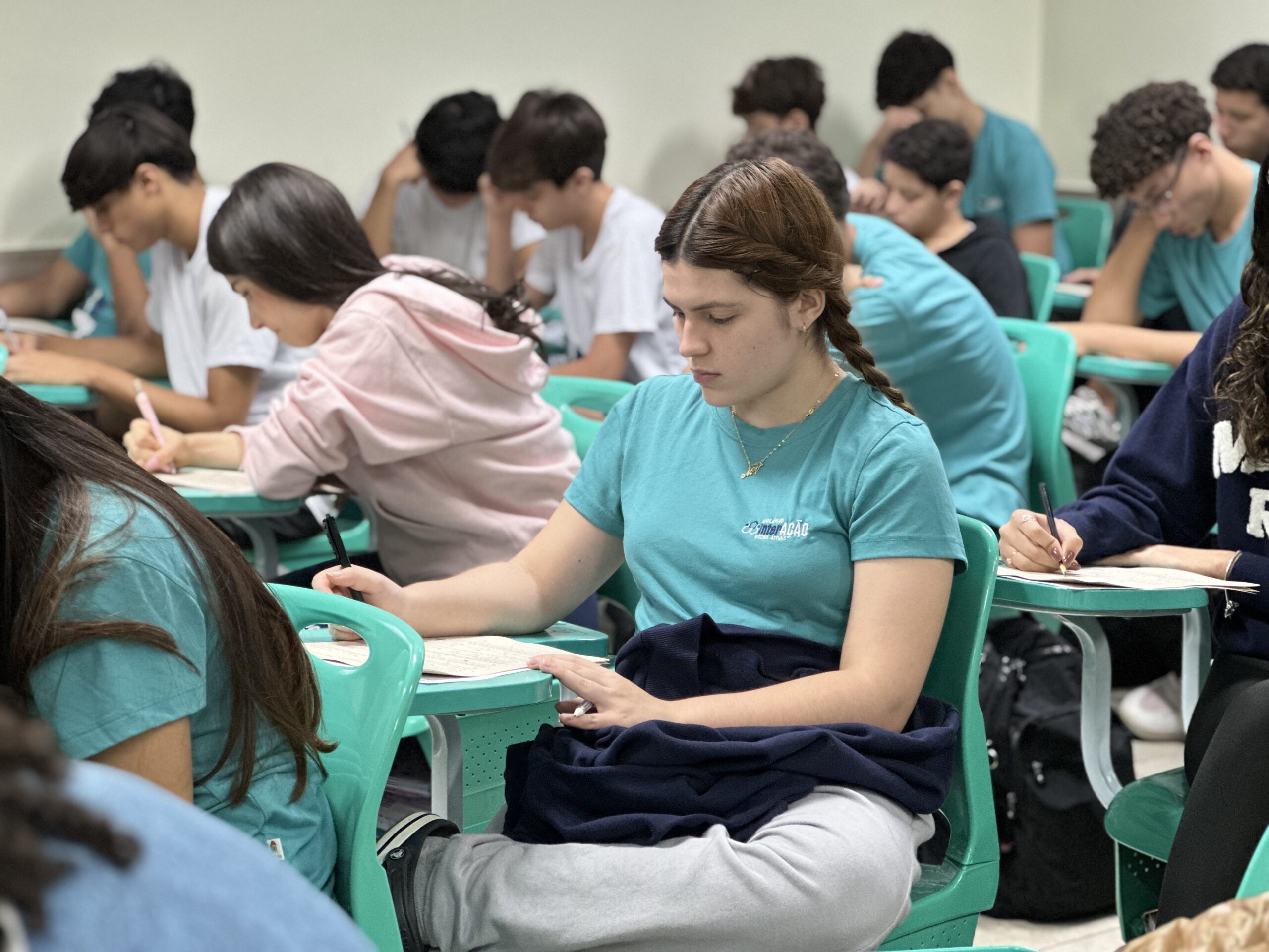 Aluna do Colégio Interação em sala de aula durante simulado, cercada de colegas