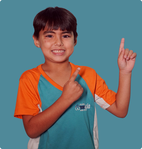 Aluno do Colégio Interação sorrindo, uniformizado, apontando para cima