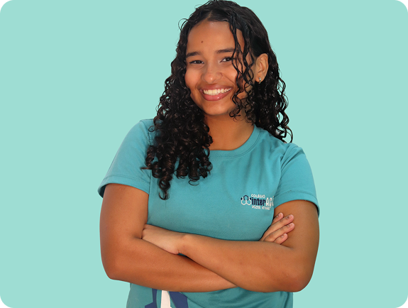 Aluna do Colégio Interação sorridente, com os braços cruzados