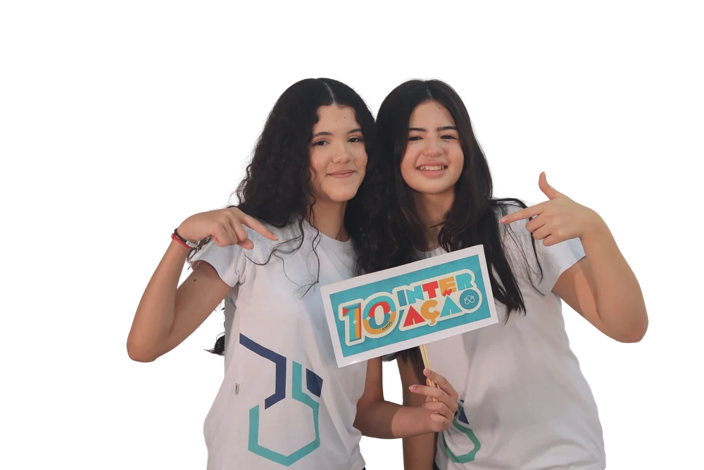 Duas alunas do Interação com a placa dos 10 anos da escola