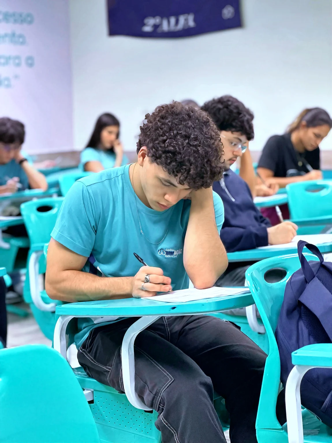 Aluno do Interação concentrado em prova, em sala de aula